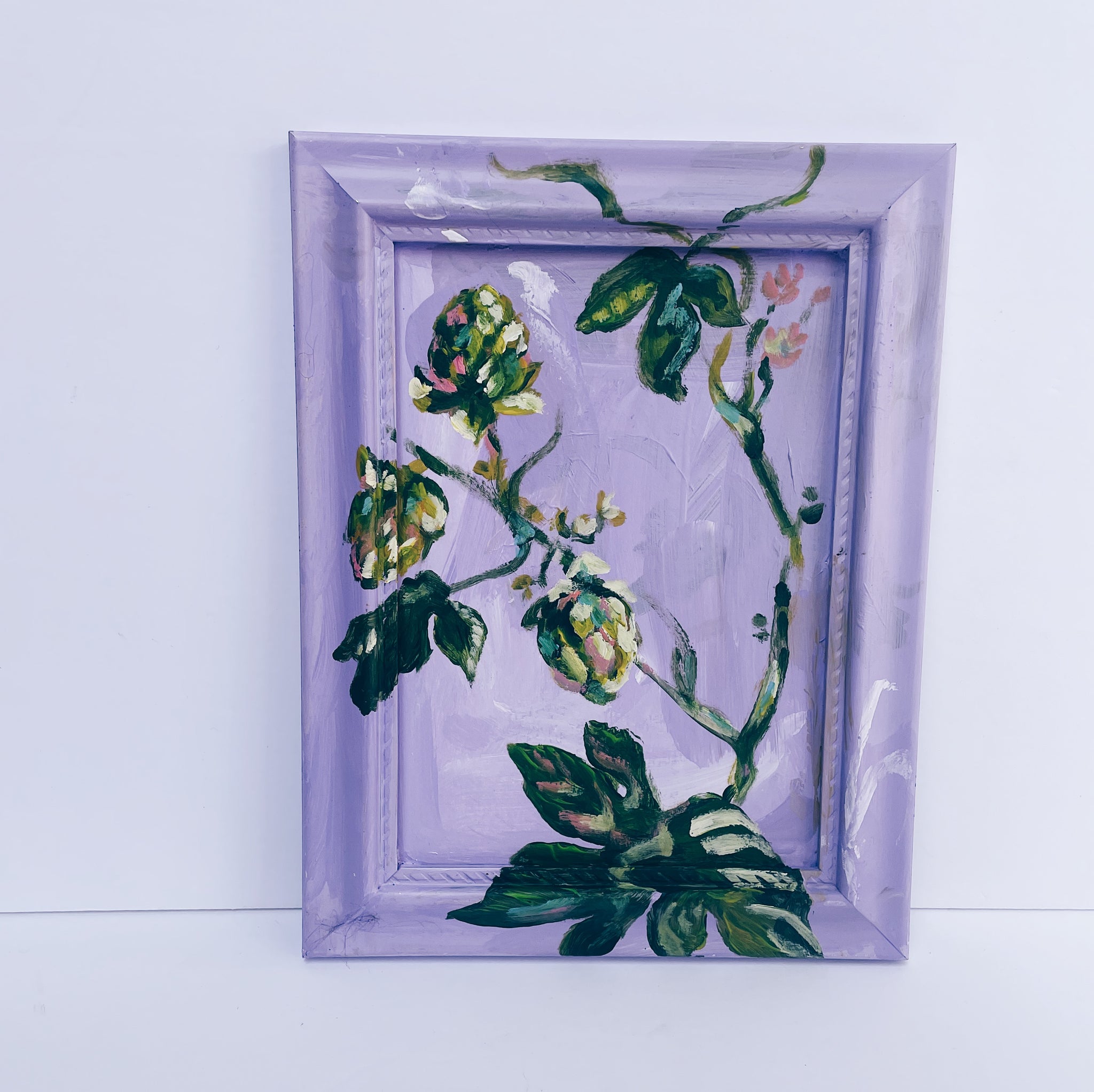 purple painting of vines and hop leaves climbing a vintage frame